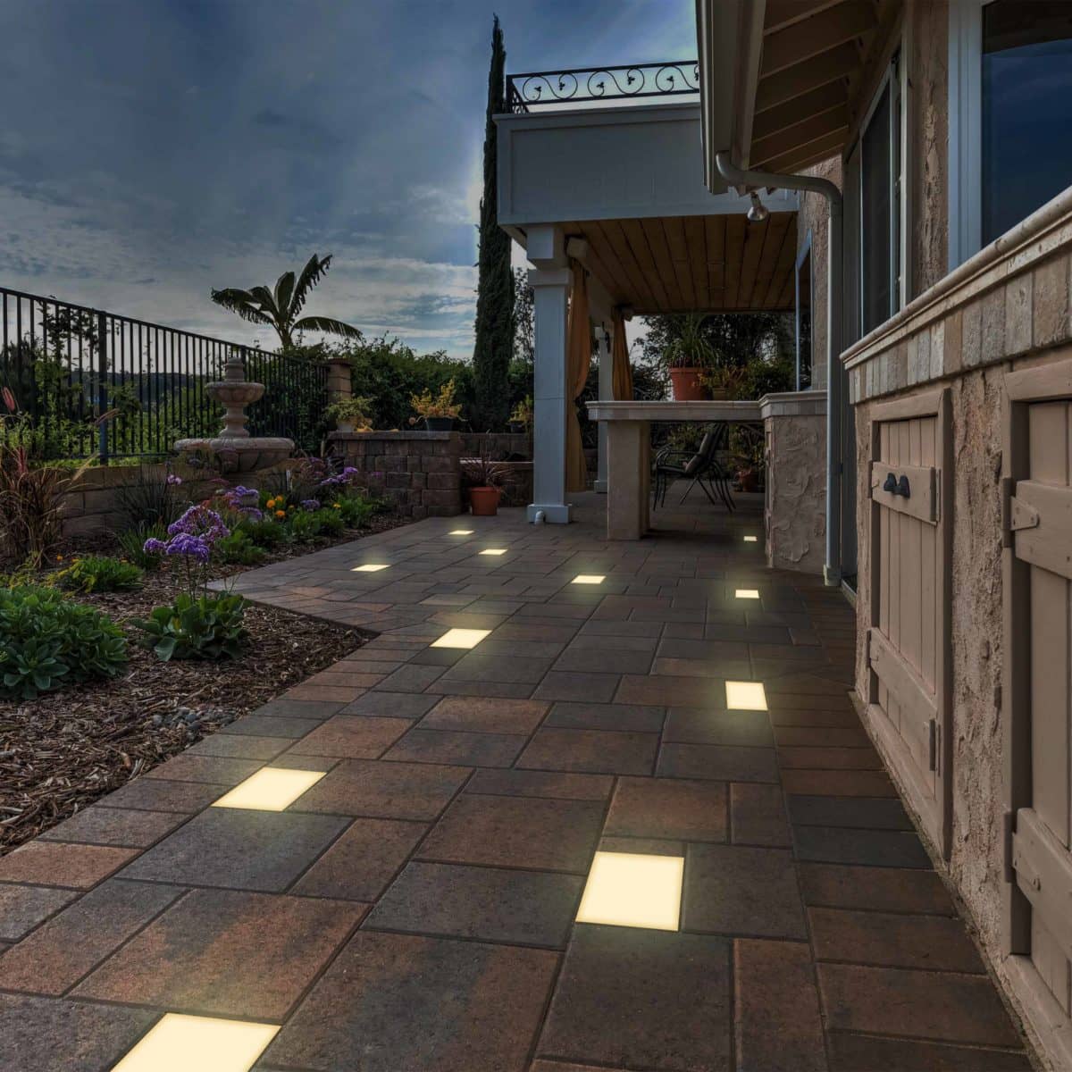 Landscape scene with paver lights illuminating a winding pathway