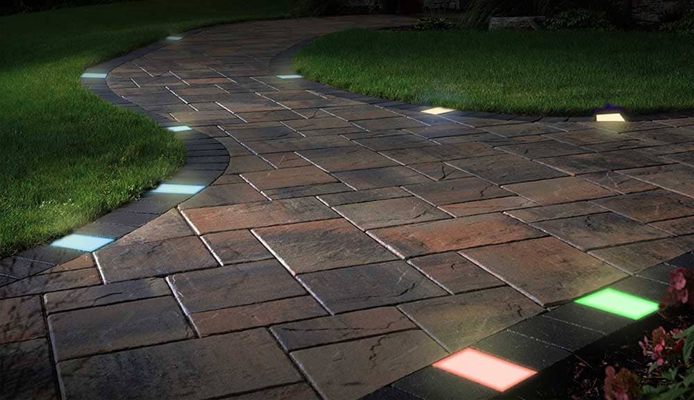 Lumengy paver lights in RGBWW colors on a brick surface