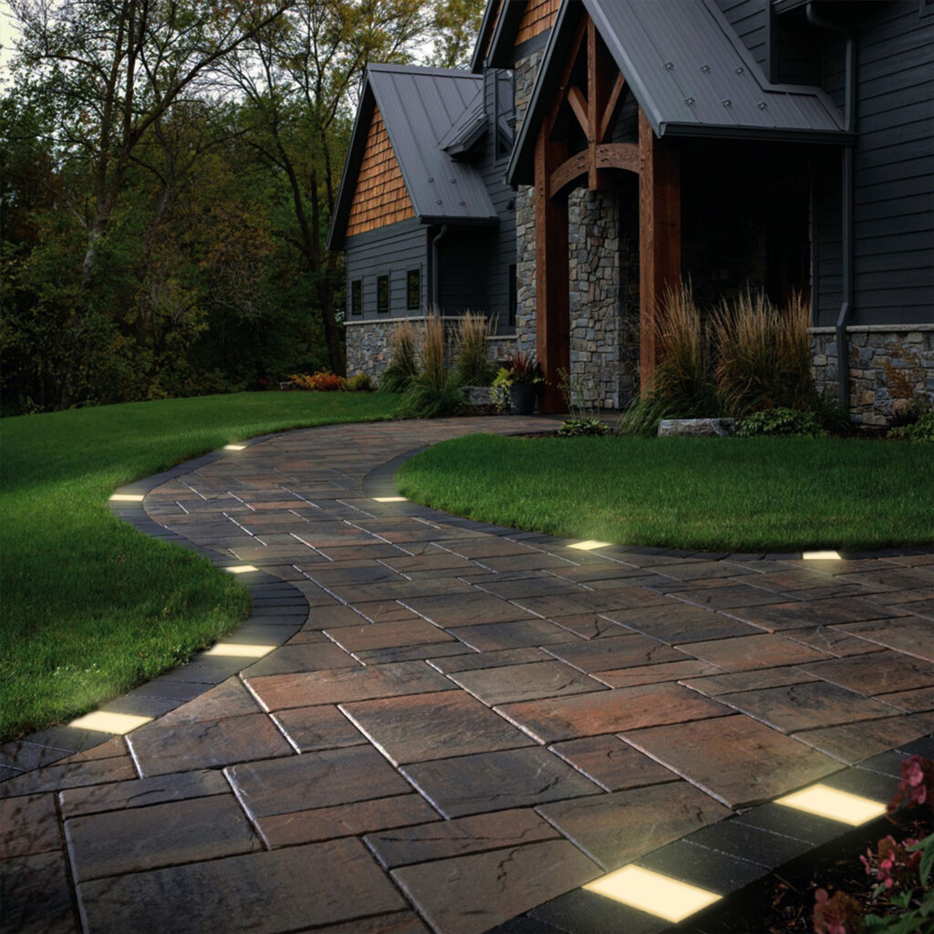 Paver lights create a warm glow in front of the house, captured in our lighting spotlight.