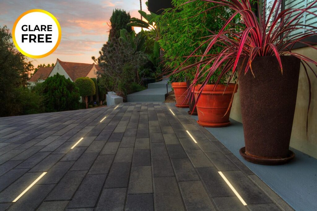 Radiant lights in the paved yard transform the outdoor space, highlighting a charming tub area